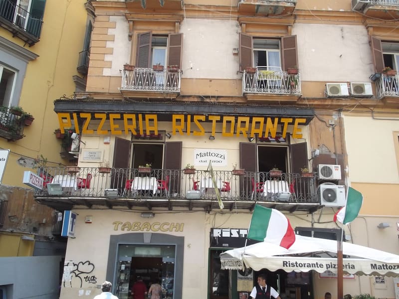 Foto di esempio: insegna di una pizzeria ristorante con i tavoli sul balcone, a Napoli